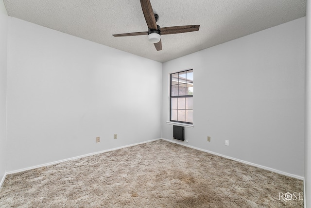 carpeted empty room featuring baseboards, a ceiling fan, and a textured ceiling