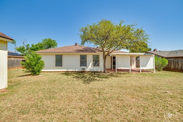 rear view of house featuring a yard, a patio, and a fenced backyard
