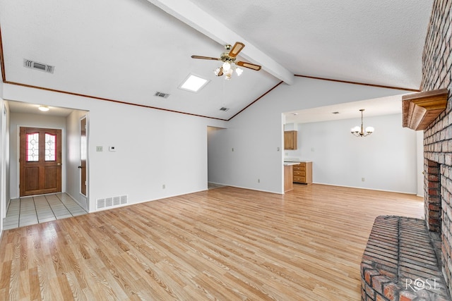 unfurnished living room with visible vents, ceiling fan with notable chandelier, and light wood-type flooring