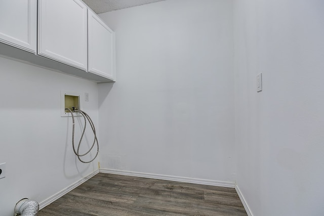 clothes washing area with cabinets, dark hardwood / wood-style floors, hookup for a washing machine, and a textured ceiling