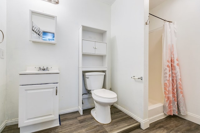 bathroom with wood-type flooring, toilet, curtained shower, and vanity