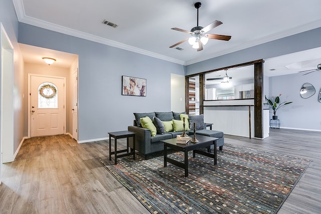 living room featuring crown molding, ceiling fan, and wood-type flooring