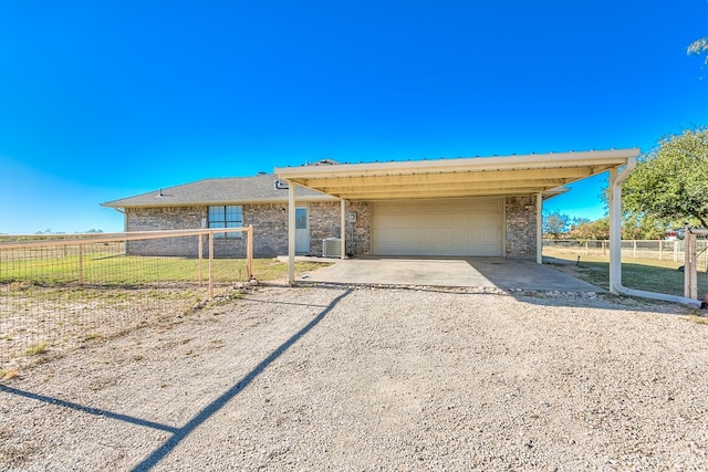 ranch-style house featuring a garage, central AC unit, and a front yard