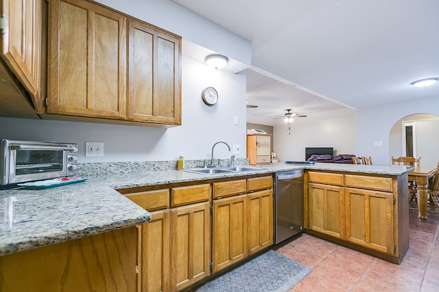 kitchen with sink, stainless steel dishwasher, kitchen peninsula, ceiling fan, and light stone countertops