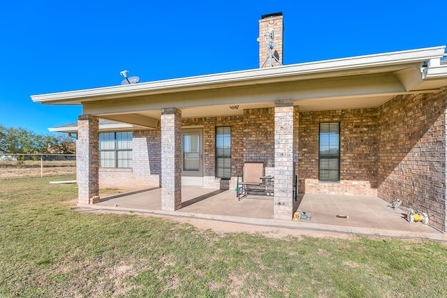 rear view of house featuring a lawn and a patio