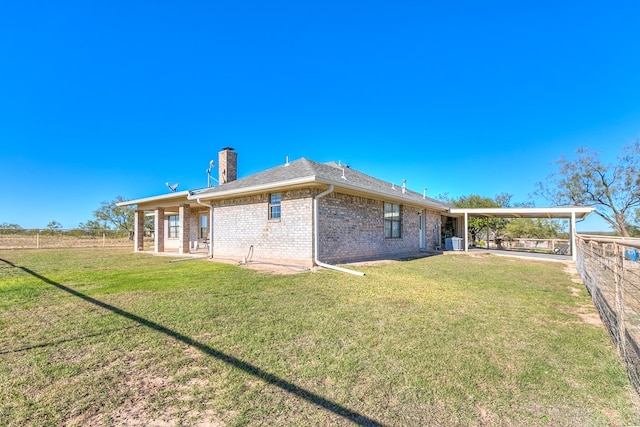 back of property with a yard and central AC unit