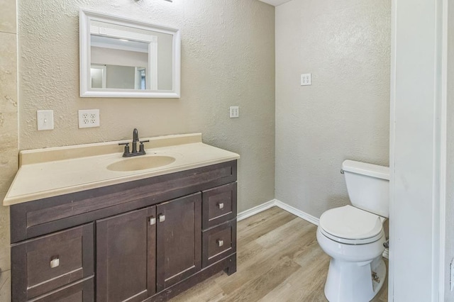 bathroom with hardwood / wood-style flooring, vanity, and toilet