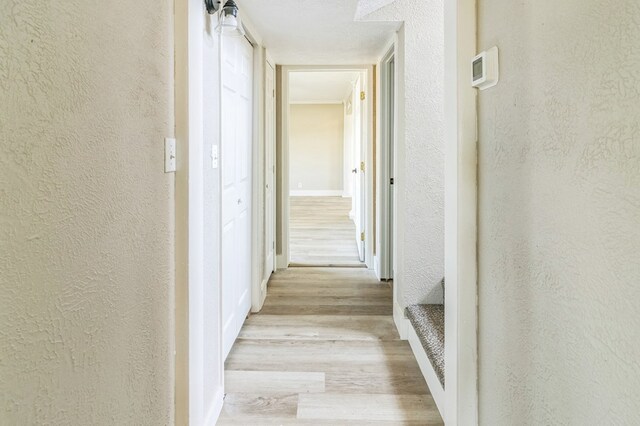 corridor with light hardwood / wood-style flooring