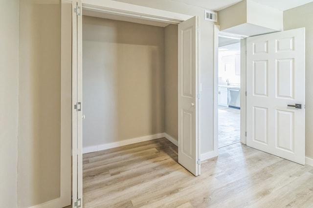 corridor with light hardwood / wood-style floors