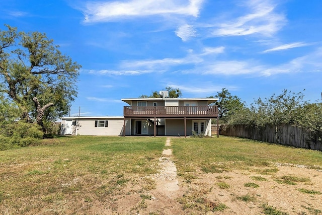 back of house featuring a wooden deck and a lawn