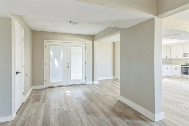 interior space with light hardwood / wood-style flooring and french doors