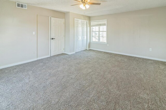 unfurnished bedroom featuring ceiling fan, carpet flooring, and a textured ceiling