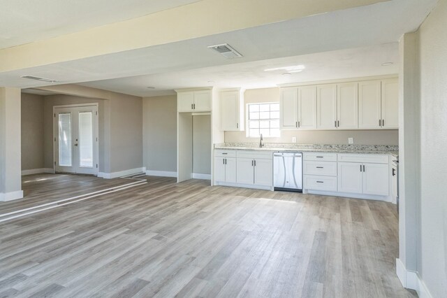 kitchen featuring white cabinetry, light stone countertops, stainless steel dishwasher, and light hardwood / wood-style floors