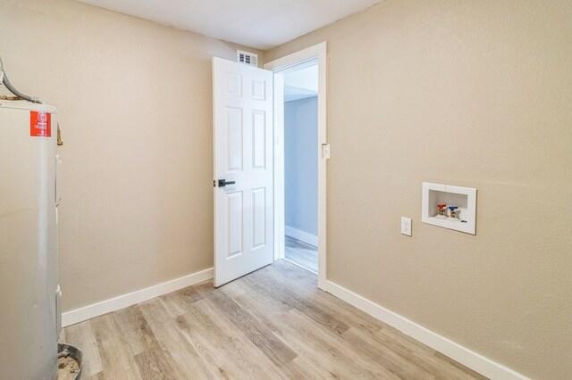 laundry area with electric water heater, washer hookup, and light hardwood / wood-style flooring