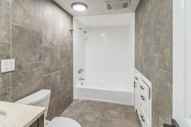 full bathroom with vanity, toilet, tub / shower combination, and tile walls