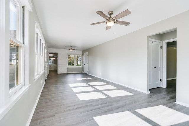 unfurnished living room featuring ceiling fan and light wood-type flooring