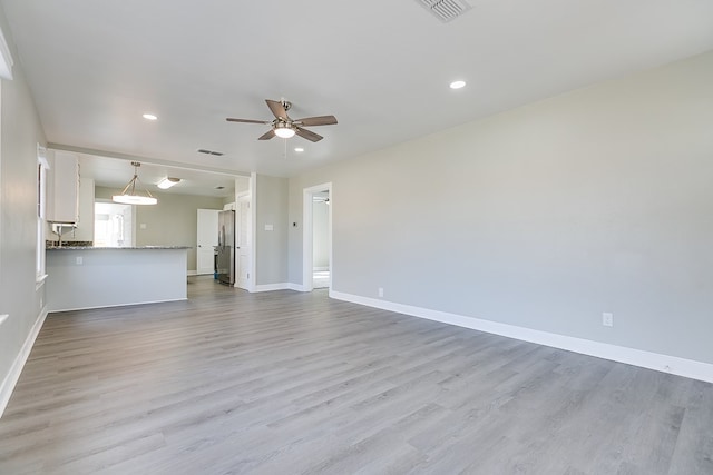 unfurnished living room with ceiling fan and light wood-type flooring