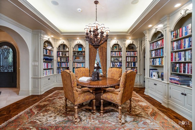 dining area featuring built in shelves, ornamental molding, and a chandelier