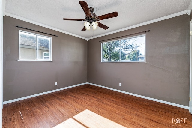 empty room with hardwood / wood-style flooring, ornamental molding, and a textured ceiling