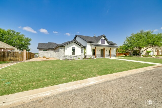 2734 Oak Hills Trl, San Angelo, TX 76904 - modern farmhouse featuring stone siding, board and batten siding, covered porch, a chimney, and a shingled roof