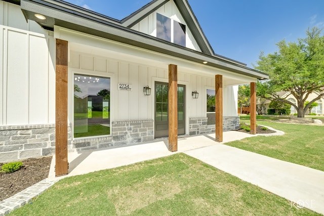 2734 Oak Hills Trl, San Angelo, TX 76904 - entrance to property with board and batten siding, a porch, and a lawn