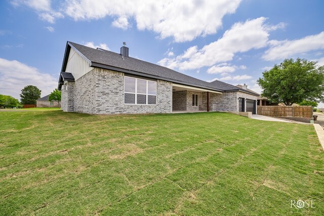 2734 Oak Hills Trl, San Angelo, TX 76904 - back of house featuring an attached garage, brick siding, concrete driveway, a chimney, and a patio