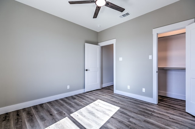 unfurnished bedroom with ceiling fan, dark hardwood / wood-style floors, and a closet