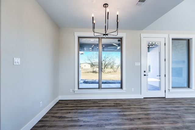 unfurnished dining area featuring dark hardwood / wood-style floors and an inviting chandelier