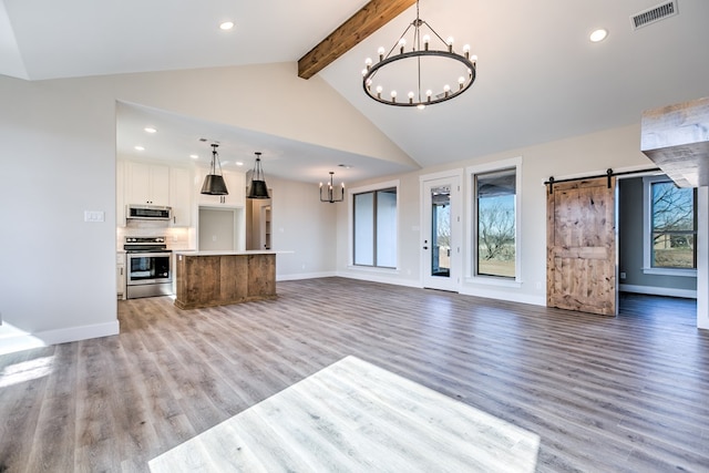 unfurnished living room with an inviting chandelier, high vaulted ceiling, light hardwood / wood-style flooring, beamed ceiling, and a barn door