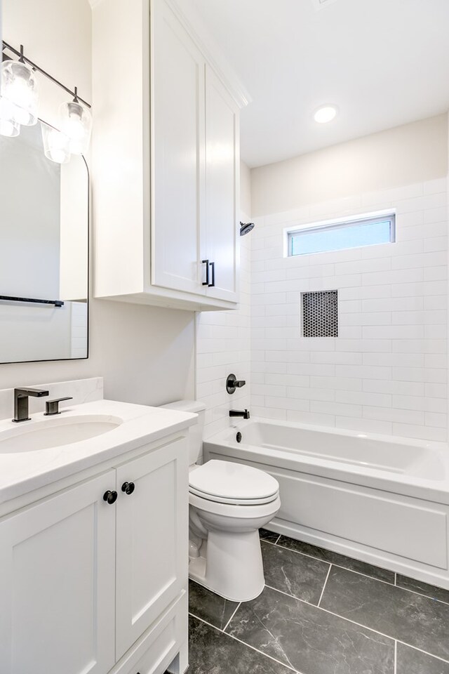 full bathroom with tiled shower / bath, vanity, and toilet