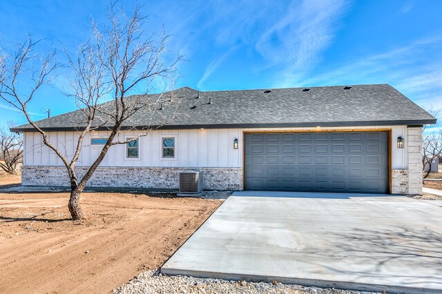 view of front of property with a garage and central AC