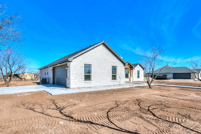 view of property exterior featuring cooling unit and a garage