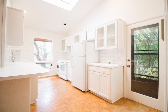 27 Yucca St, San Angelo, TX 76901 - kitchen with white appliances, a sink, a skylight, lofted ceiling, and decorative backsplash