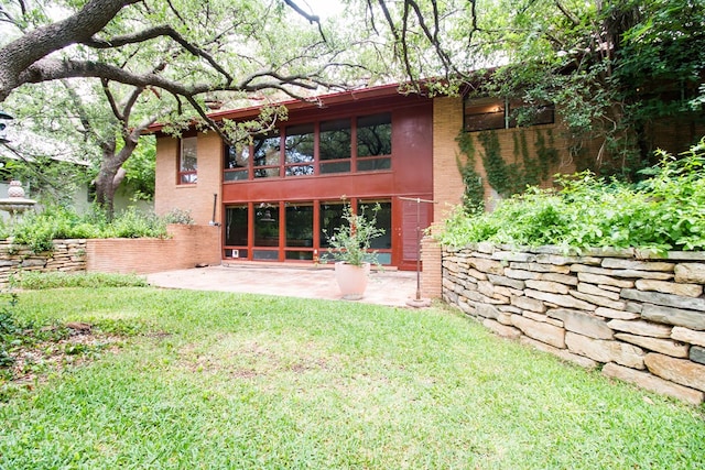 27 Yucca St, San Angelo, TX 76901 - back of house with a patio area, a lawn, stucco siding, and brick siding