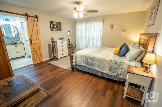 3709 Tridens Trl, San Angelo, TX 76904 - bedroom featuring a barn door, wood finished floors, ensuite bathroom, and ceiling fan