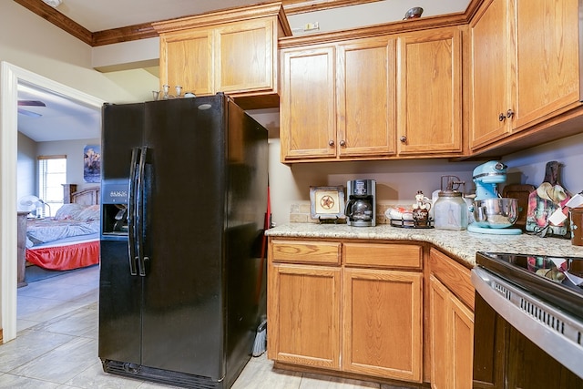 kitchen featuring range with electric cooktop, ornamental molding, black fridge with ice dispenser, and light stone countertops