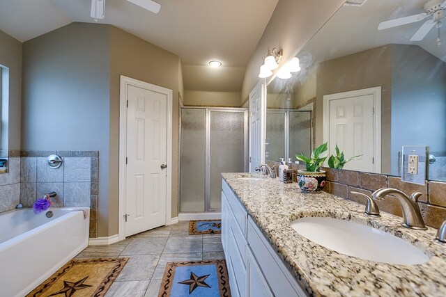 bathroom featuring vaulted ceiling, shower with separate bathtub, vanity, ceiling fan, and tile patterned floors