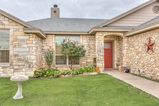 entrance to property featuring a lawn