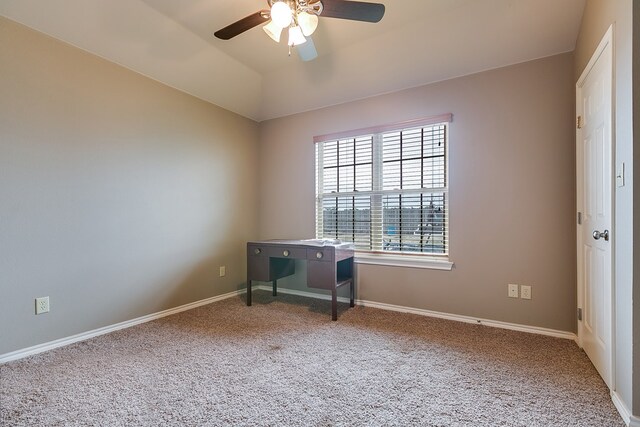 unfurnished office with vaulted ceiling, ceiling fan, and carpet floors