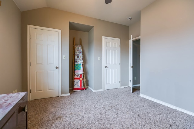 unfurnished bedroom featuring carpet and lofted ceiling