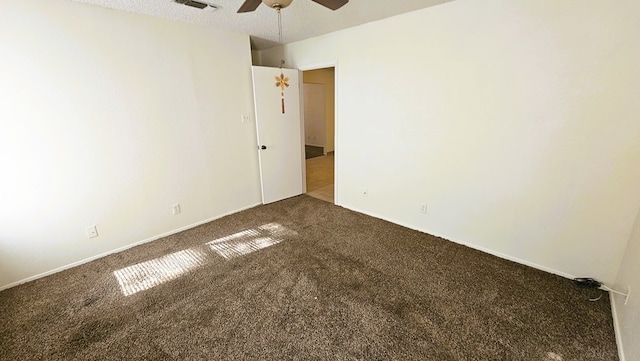 unfurnished room with ceiling fan and dark colored carpet