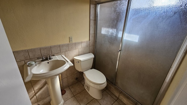 bathroom with tile walls, tile patterned floors, and toilet