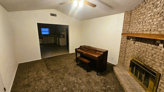 interior space featuring vaulted ceiling, dark carpet, and a textured ceiling