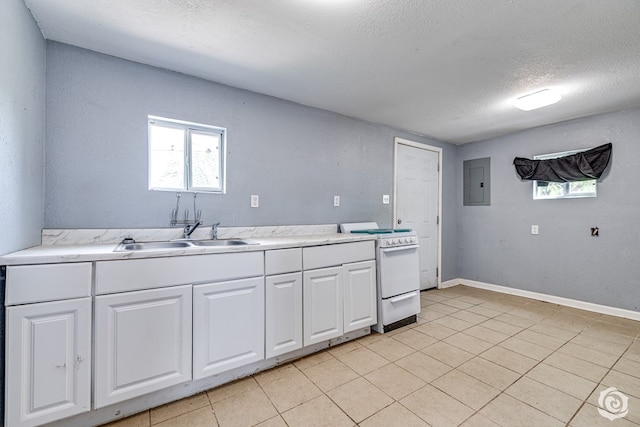 kitchen featuring white electric stove, plenty of natural light, light countertops, a sink, and electric panel