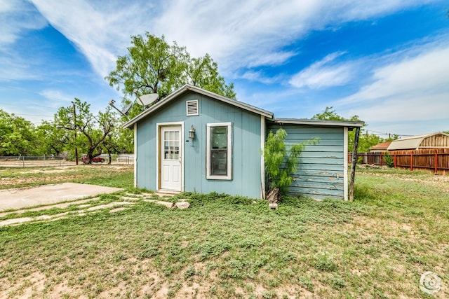 view of outbuilding featuring fence