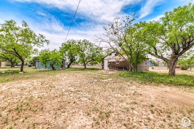 view of yard with fence and an outbuilding