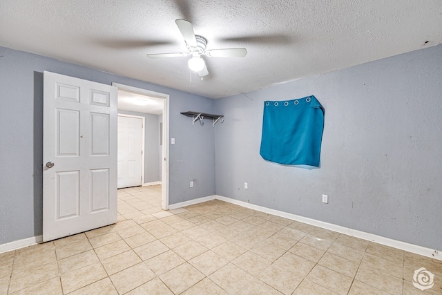 unfurnished bedroom featuring baseboards, a textured ceiling, and light tile patterned floors
