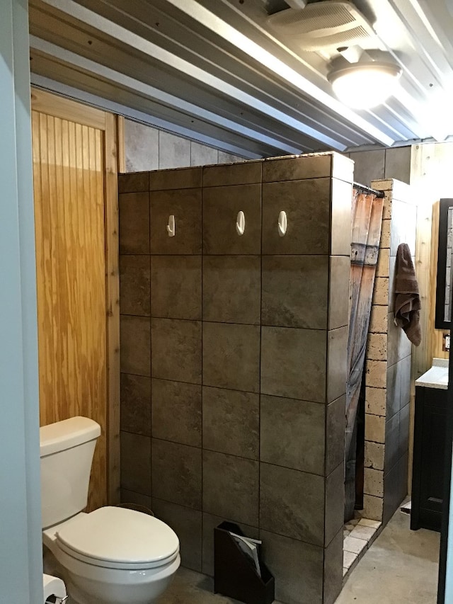 bathroom with vanity, toilet, and concrete flooring