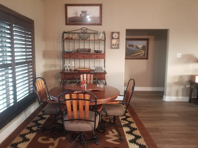 dining space with dark hardwood / wood-style flooring