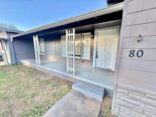 view of exterior entry with a porch